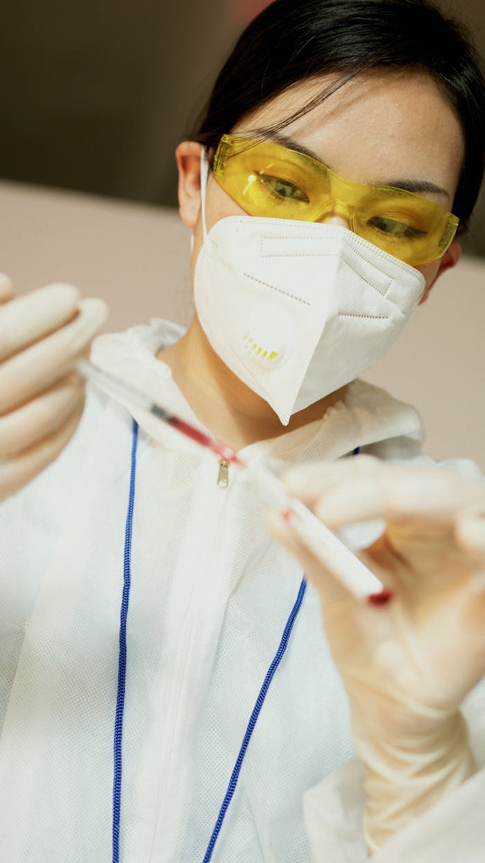 Close-up of a researcher in protective gear conducting a laboratory experiment with precise tools.